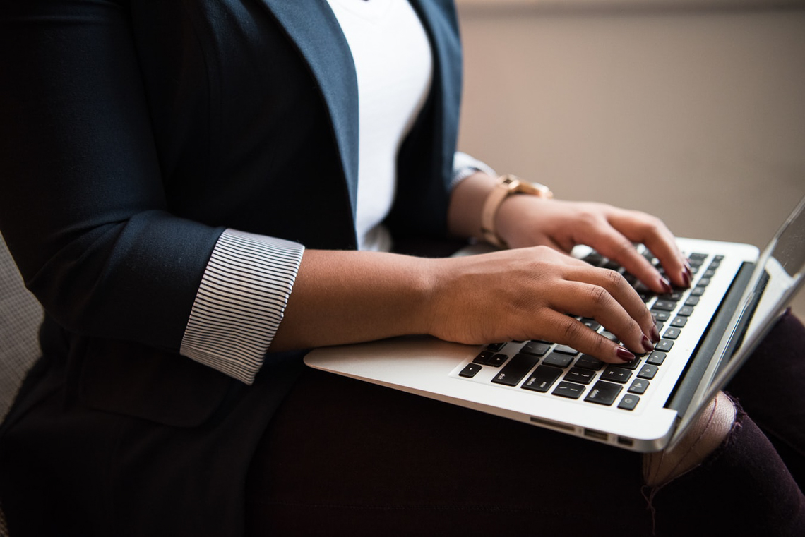 Close up of a Black woman typing on a keyboard