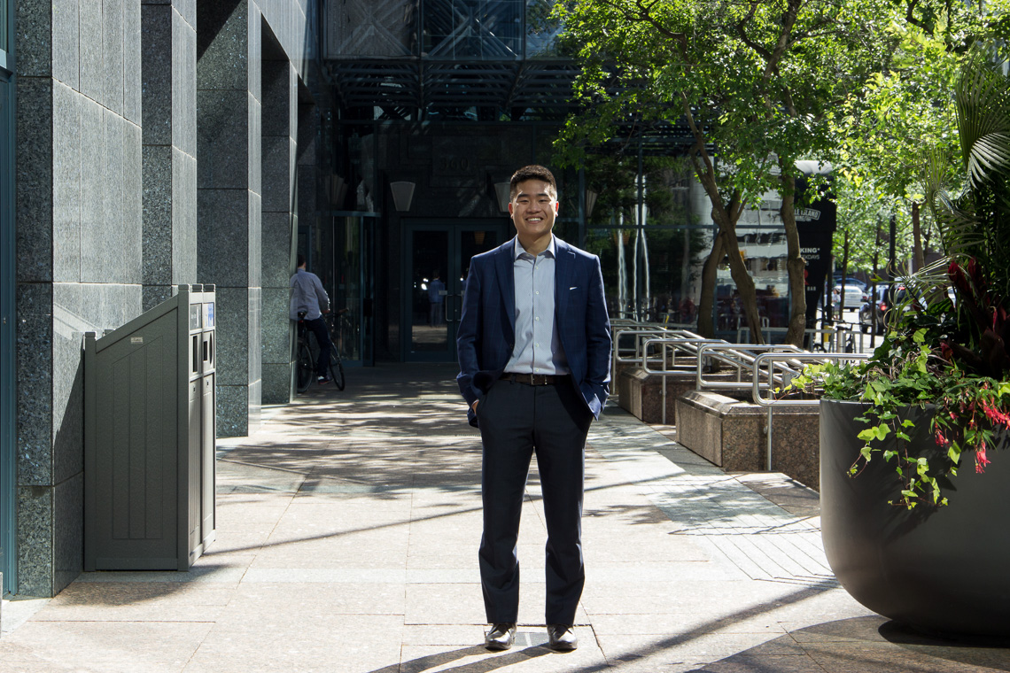 A man wearing a business suit standing in a downtown location.