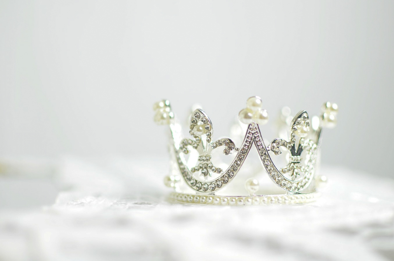 Sparkling white and gold crown on a white background.