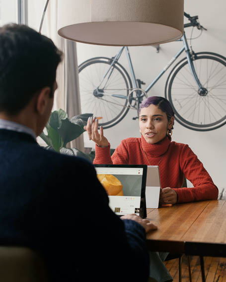 Two people sitting across from each other at a table and talking