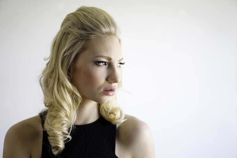 Headshot of a blonde wamon on a white background looking to the right.