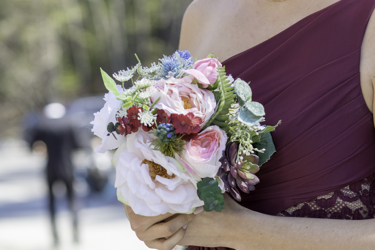 Close up of a woman in a red dress holding a bouquet.