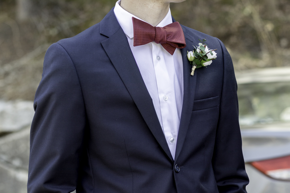 Close up of a man in a wedding suit with a boutonierre.